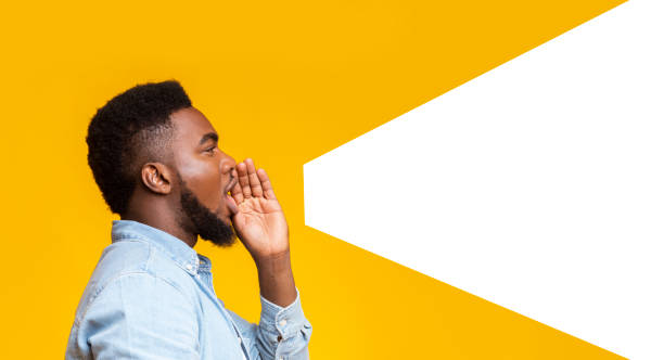 Guy making loud announcement at copy space on yellow background African american man making loud announcement at copy space, holding hand near his open mouth over yellow background, side view voice stock pictures, royalty-free photos & images