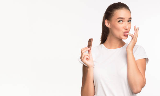 소녀 먹는 초콜릿 과 핥기 손가락 서 에 화이트 배경 - finger licking 뉴스 사진 이미지