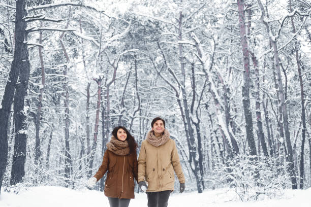 istock Happy Spouses Walking Holding Hands In Winter Forest 1187798648