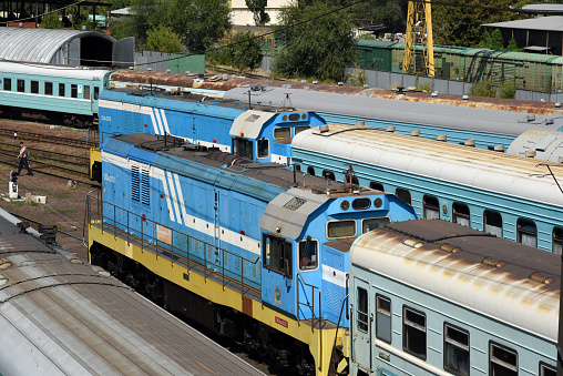 Kazakhstan Train composition at the Almaty Railway Station 2. The Image shows two trains wit locomotives awaiting their departure during a hot summer day.