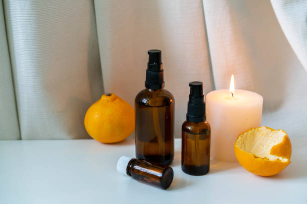 istock Aromatherapy essential oils in glass bottles with fresh citrus fruit and white candle on white drapery background. 1187801164