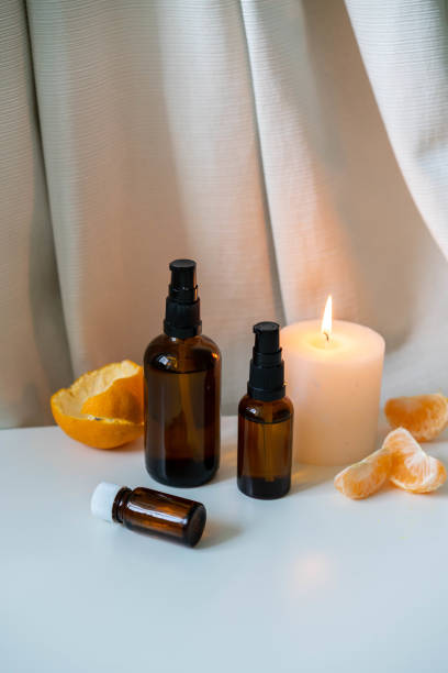 istock Essential oils in glass bottles with fresh citrus fruit and white candle on white drapery background. Aromatherapy concept photo, verticall orientation. 1187801165