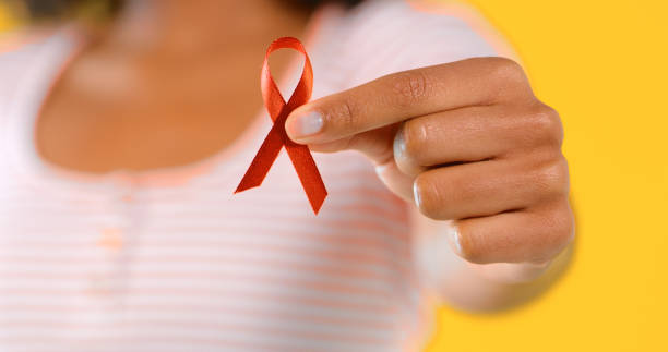Get educated Studio shot of an unrecognizable woman holding up a red HIV/AIDS awareness ribbon world aids day stock pictures, royalty-free photos & images