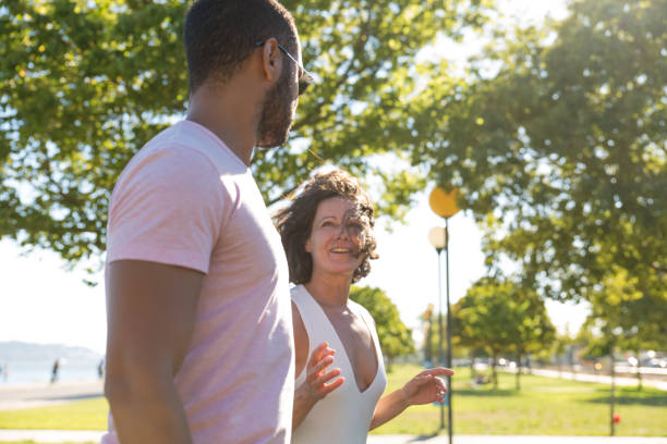 istock Smiling couple walking in park 1187804947