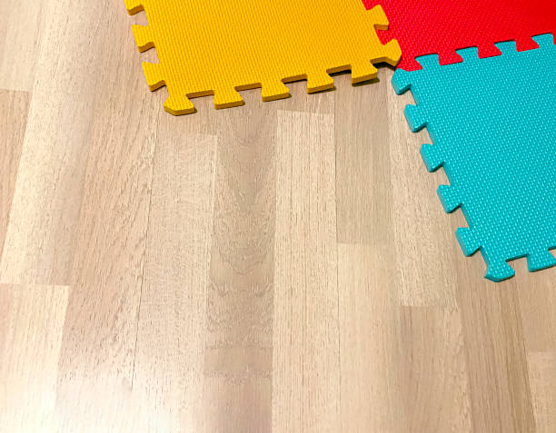 istock Soft rubber mat composed of colored blocks intersected with each other on a wooden floor 1187805045