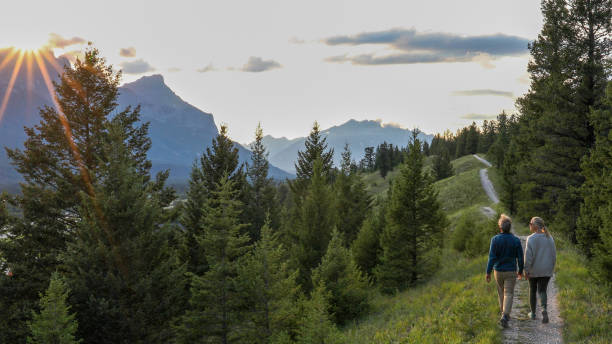 dojrzała para idzie szlakiem o wschodzie słońca - rocky mountains zdjęcia i obrazy z banku zdjęć