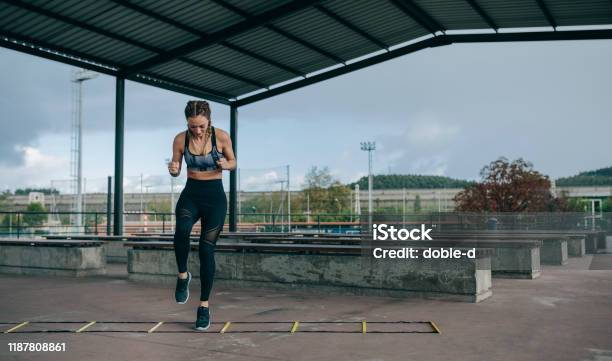 Sportlerin Springt Auf Einer Agilitätsleiter Stockfoto und mehr Bilder von Leiter - Leiter, Beweglichkeit, Fitnesstraining