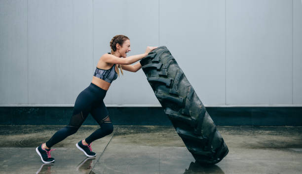 istock Sportswoman doing cross-training lifting a tire 1187808890