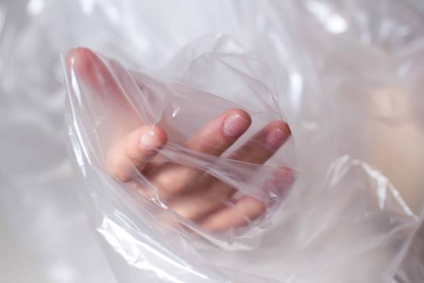 istock young womans hand covered in transparent plastic bag reaching out 1187809806