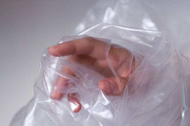 istock young womans hand covered in transparent plastic bag reaching out 1187809899