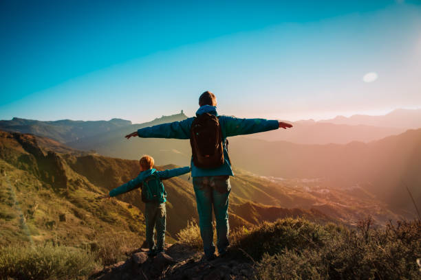 istock Happy father and son hiking at sunset mountains 1187812311
