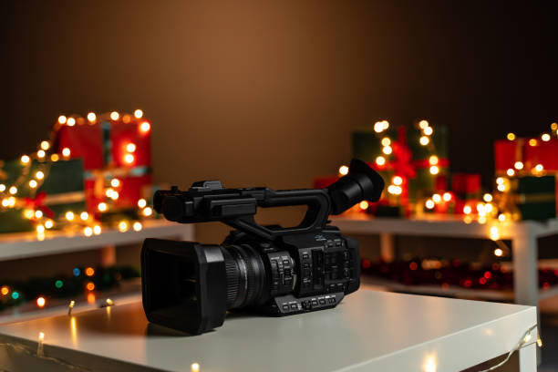 istock Home video camera in front Christmas lights  and presents in background 1187813553