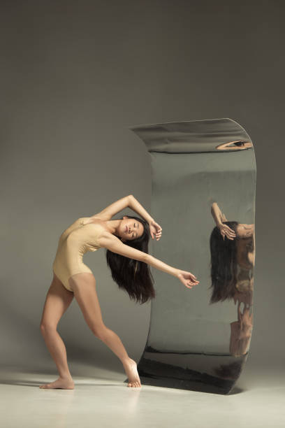 istock Young and stylish modern ballet dancer on brown background 1187813656