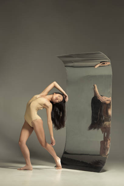 istock Young and stylish modern ballet dancer on brown background 1187813660