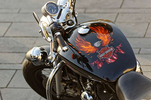 Dolmabahce, Istanbul / Turkey - November 10 2019: Harley Davidson Chopper dashboard and fuel tank painted with burning eagle and Turkish Flag. Protection helmet with Harley Davidson name hanged on the grip.