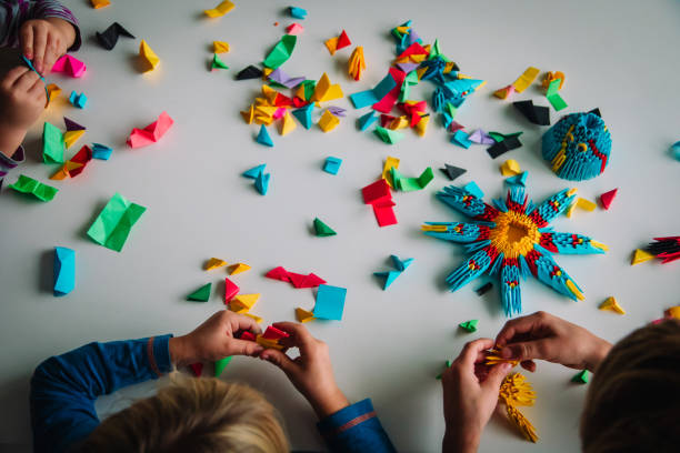 istock kids making origami crafts with paper, learning 1187814065