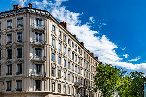 Apartment building exterior in Lyon with wrought iron balconies in several storeys of upstairs apartments.