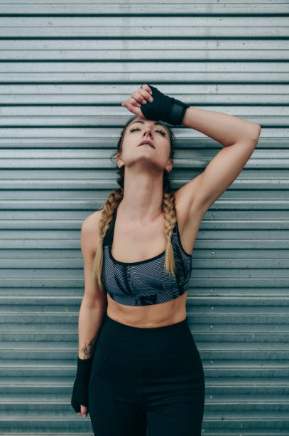 istock Sportswoman resting on a metal wall 1187817019