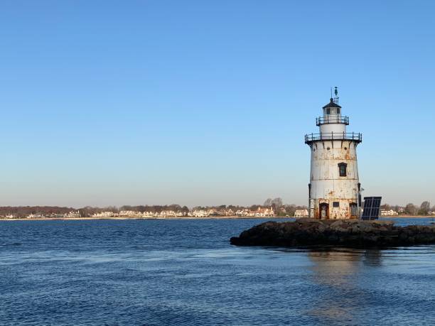 Old Saybrook Outer Lighthouse in morning The outer lighthouse in Old Saybrook Connecticut in the morning with the moon in the sky. lighthouse lighting equipment reflection rock stock pictures, royalty-free photos & images