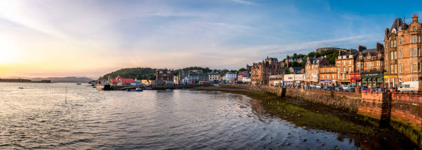 Sunset in Oban, Scotland A sunset in Oban, small Scottish Town on the sea, from where you can take a boat to the Isle of Mull. The sunset casts a orange light on the buildings. Final image is a merge of multiple shots. oban stock pictures, royalty-free photos & images