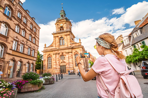 A girl traveler taking photo of the St John Baptist Church in SaarbrÑcken. Travel in Germany concept