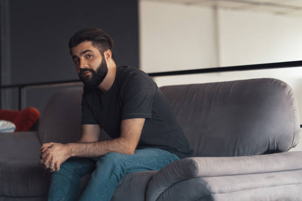 istock Young man sitting relaxing on the couch 1187821239