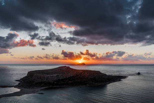 istock Sunset on the background of a small island 1187821941