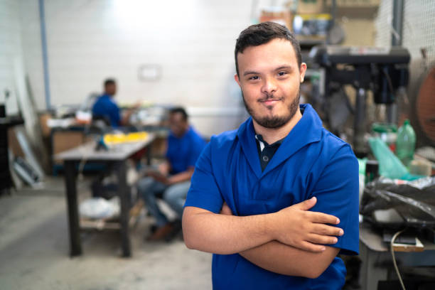Portrait of smiling special needs employee in industry Portrait of smiling special needs employee in industry disabled adult stock pictures, royalty-free photos & images