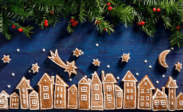 istock Christmas background, image created from gingerbread houses, fresh yew branches and gingerbread stars  on a dark blue  background. 1187824340
