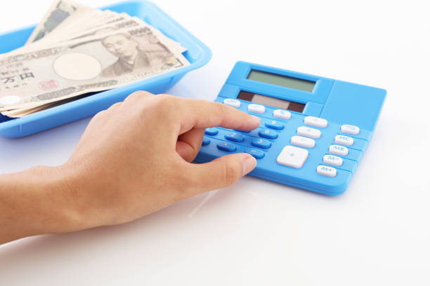 Woman counting money and working on calculator at the table