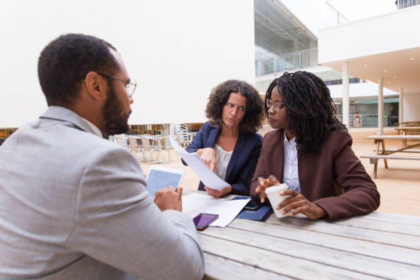 istock Multiethnic partners discussing contract in outdoor cafe 1187827335