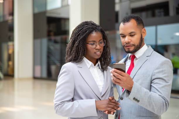 istock Positive focused colleagues looking at mobile phone screen 1187830339
