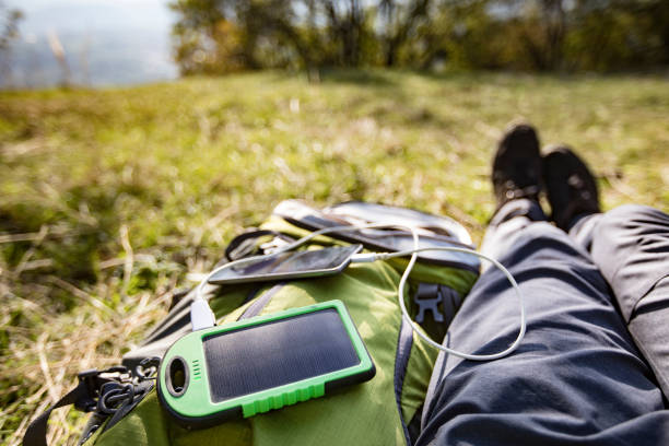 homem adulto que carrega seu telefone móvel com o painel solar portátil ch - telephone nature mobile phone autumn - fotografias e filmes do acervo