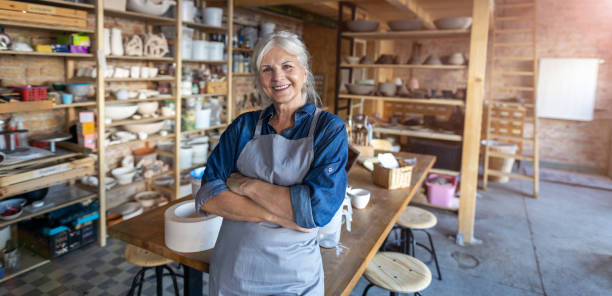 Portrait of senior female pottery artist in her art studio Portrait of senior female pottery artist in her art studio pottery photos stock pictures, royalty-free photos & images