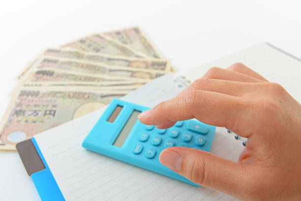 Woman counting money and working on calculator at the table