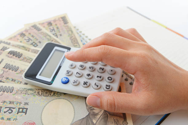 Calculator and money Woman counting money and working on calculator at the table kyushu photos stock pictures, royalty-free photos & images