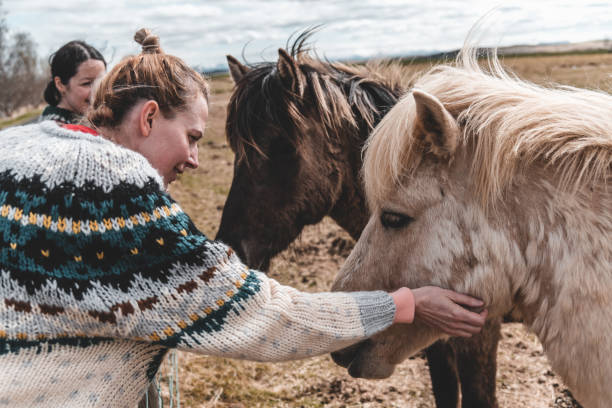 istock Two women play with horses 1187844233