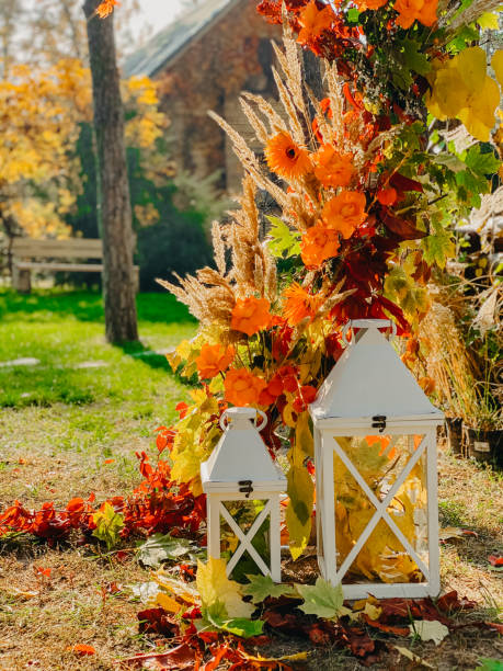 Part of a colorful wedding arch of autumn leaves, flowers and cereal ears. Part of a colorful wedding arch of autumn leaves, flowers and cereal ears on the background of the autumn forest. Closeup. country wedding arches stock pictures, royalty-free photos & images