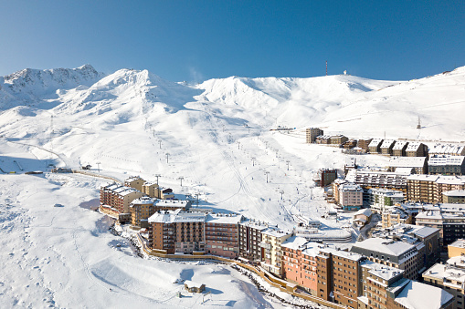 Ski lifts heading toward the top of the snow-capped mountains of Grandvalira from Pas de la Casa.