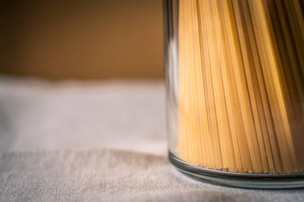 Fresh spaguetti in a glass jar on a white tablecloth