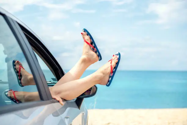 Photo of Woman relaxing in a car on the beach