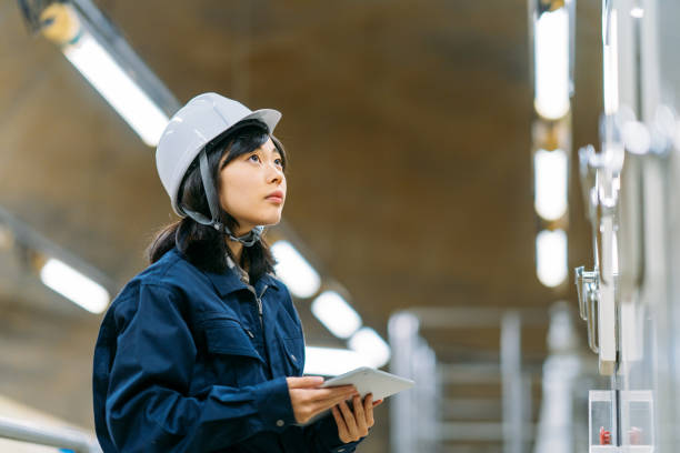 молодая женщина-инженер, работающая на инженерном объекте - manual worker portrait helmet technology стоковые фото и изображения