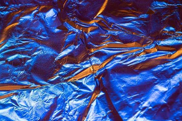 Blue red deformed background made of neon lights foil. Trendy duotone texture.