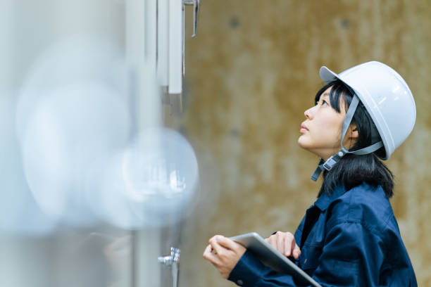 junge ingenieurin arbeitet in der ingenieurseinrichtung - manual worker portrait helmet technology stock-fotos und bilder