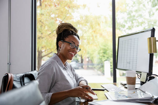 istock Small business owner smiles for camera while working 1187848630