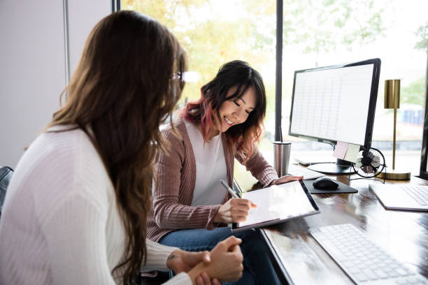 istock Unrecognizable female boss makes suggestions; employee makes changes on tablet 1187848689