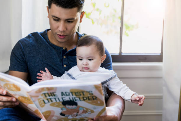 istock Baby is interested in book dad is reading 1187848774