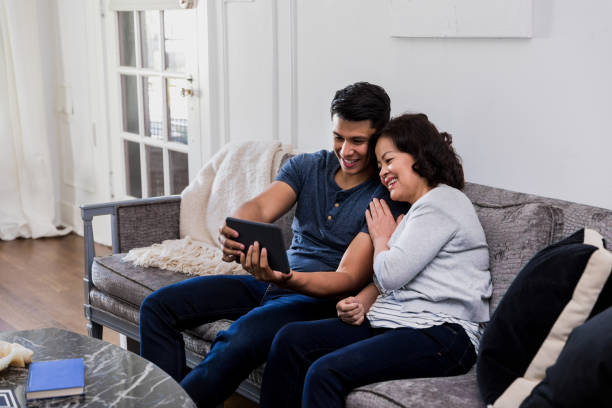 istock Son uses tablet to take selfie with mom 1187848817