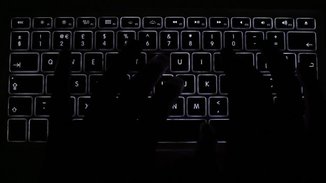 Computer keyboard typing. Dark silhouette.