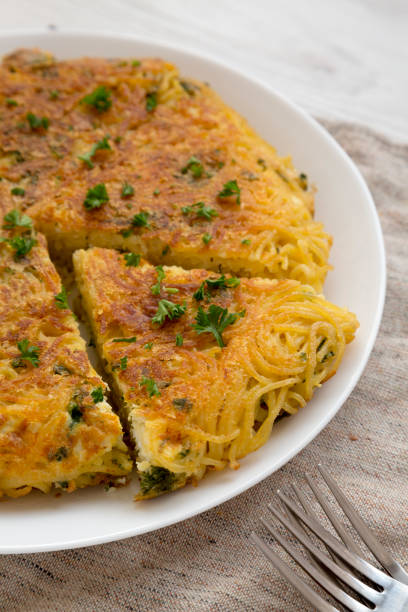 istock Homemade spaghetti omelette on a white plate, low angle view. Close-up. 1187852374